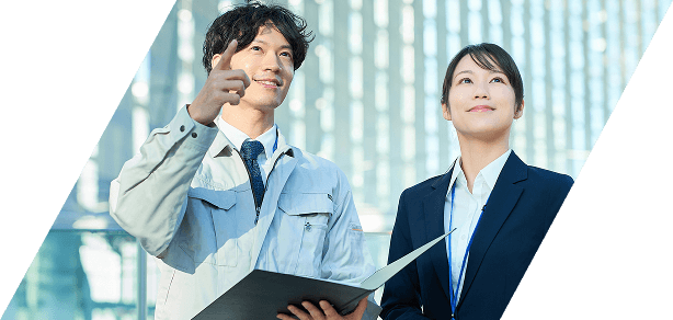 作業服を着た男性が指をさしている方向に女性が目を向けている