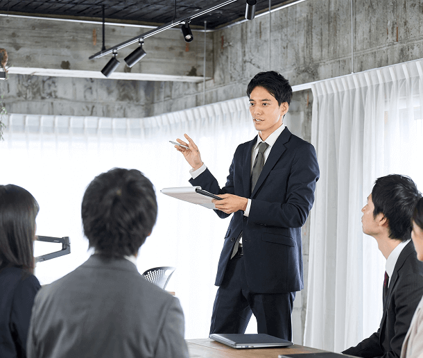 スーツの男性が新入社員に研修している